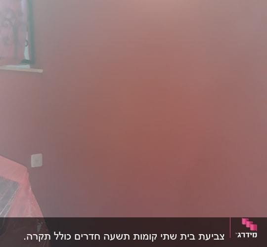 קיר צבוע באדום עם ניילון על רהיט